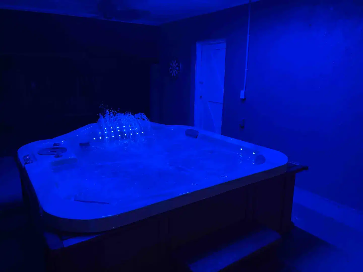 Private, covered hot tub at night with LEDs lit.