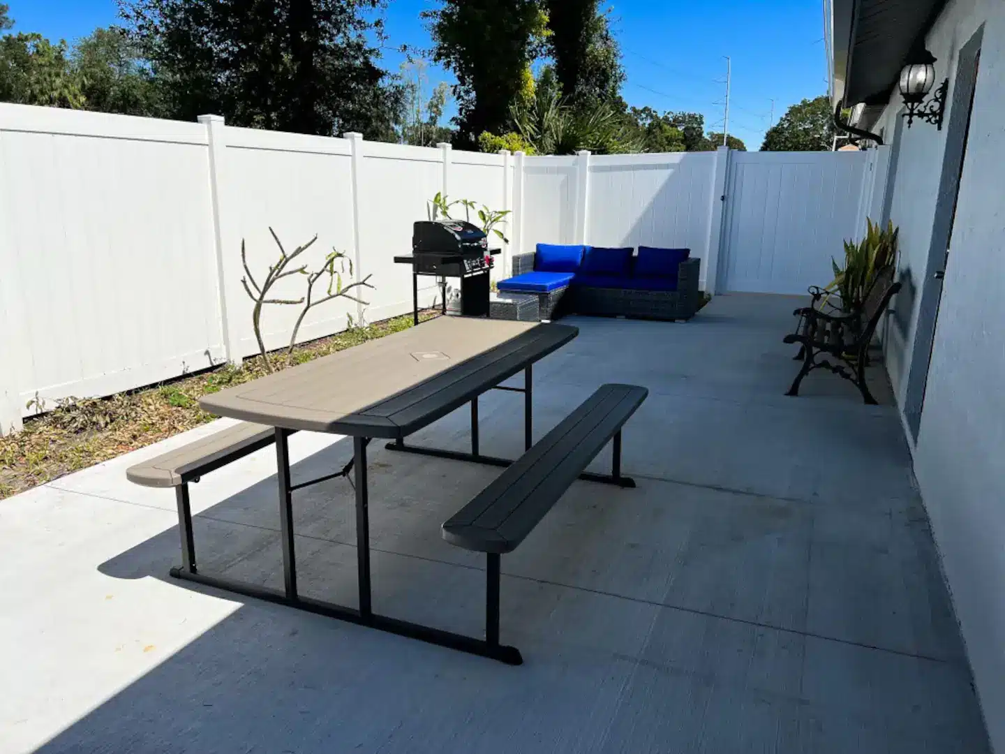 An outdoor area with lounge seating’s, picnic table, and BBQ.