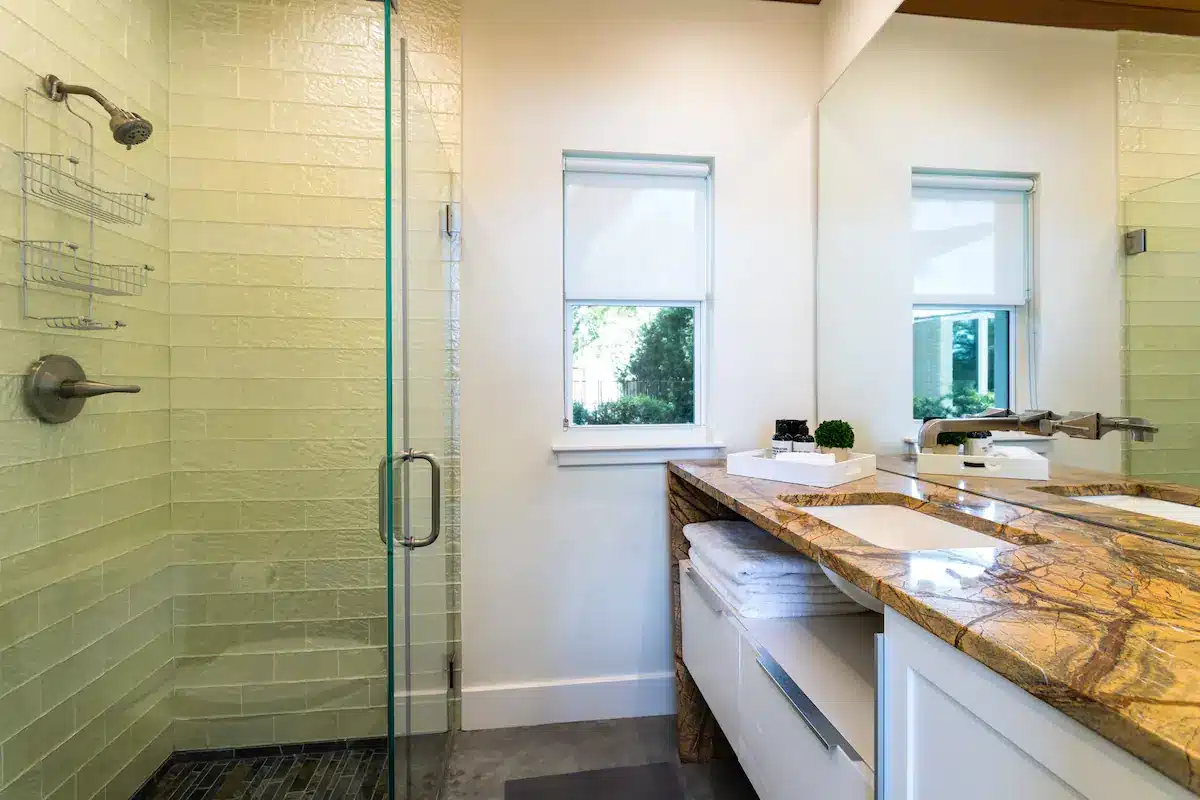 Bathroom with Spacious Granite Countertop and Glass Shower Door