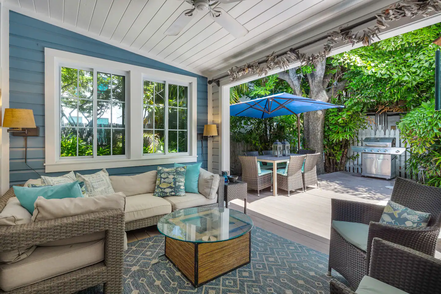 There is an outdoor table and nearby gas grill for outside/open air dining.